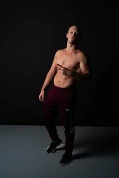 After training, he put up two fingers in sports black trousers and shorts with a Stock Photos