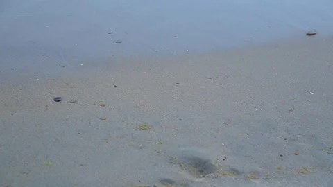 After the waves, human footprints appear in the sand and 2019 Stock-Footage 96313717