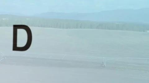 After wide pale-blue field view, 3D word cube emerging, scaling, rotating to Stock Footage 329909327