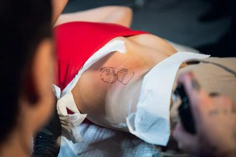 After the work done, the tattoo master processes the client's skin to heal Stock Photos
