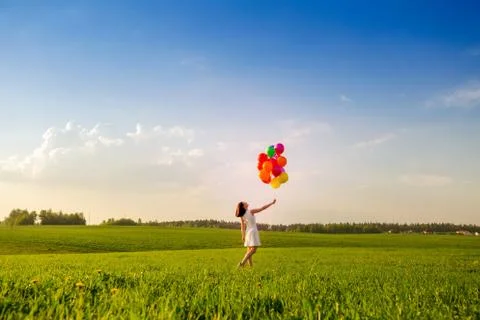 After work time outdoors theme. Girl with color air balloons on summer green  Stock Photos