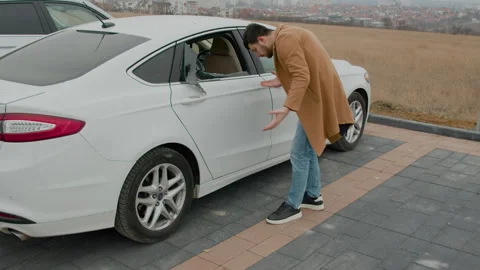 In the aftermath of auto theft, a car bears a shattered window, leaving the Stock Footage 267074757