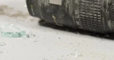 The aftermath of destroying a camera and lens with glass, dirt and broken pieces Stock Footage 236346618