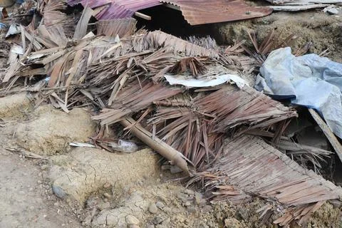 Aftermath of Destruction with Rubble, Thatch, and Metal Debris Foto stock