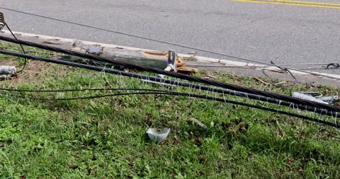 In aftermath of a hurricane, damaged power lines lie on ground with broken wires Stock Footage 306859626