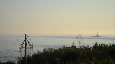 Afternoon at the ocean and distant lighthouse Stock Footage 8660935