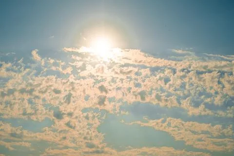 Afternoon, sun  bright in sky, casting light on fluffy white clouds. blue sky Stock Photos