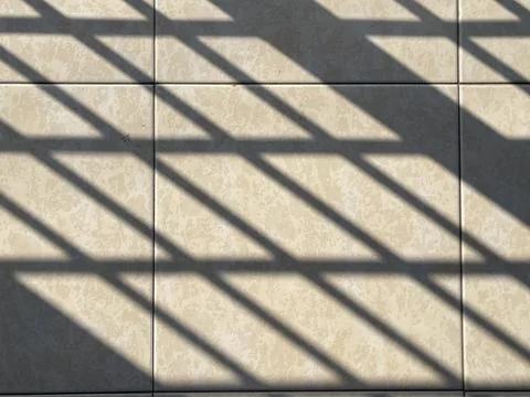 Afternoon Sunlight Casting Iron Gate Shadows on Floor Tiles Stock Photos