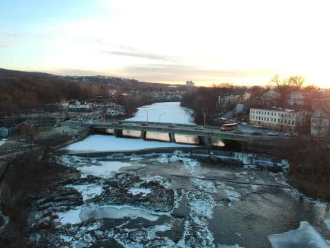 Afternoon sunset on icy river near bridge Stock Photos