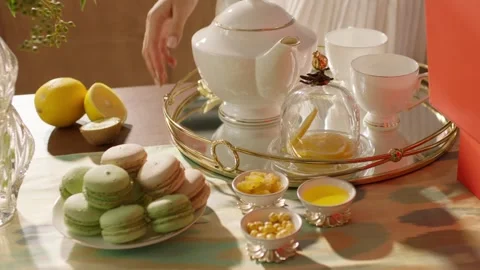 Afternoon Tea Set with Macarons, Lemon and Teapot on Table Stock Footage 335865686