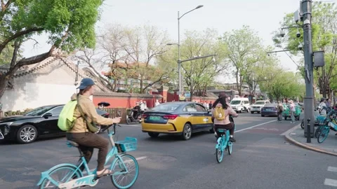 Afternoon traffic at Beijing intersection with scooters, cars, and pedestrians Stock Footage 336025812