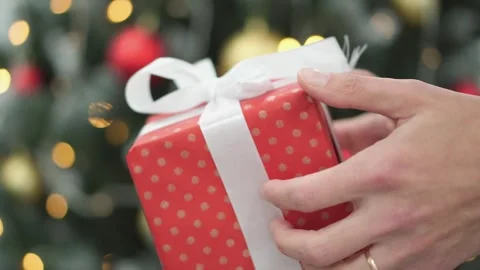 Against the backdrop of a Christmas tree and flashing garlands, people exchange Vidéo 257883670