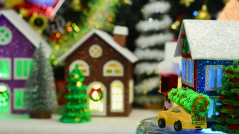 Against the backdrop of a large Christmas town, a three-colored house rotates Stock Footage 293427858