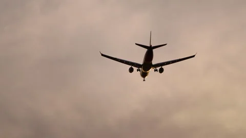 Against the backdrop of picturesque clouds, a passenger plane coming in for Vídeos de archivo 253301532
