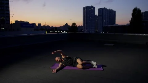 Against the background of a beautiful sunset, a man is doing sports. Video stock 262573699