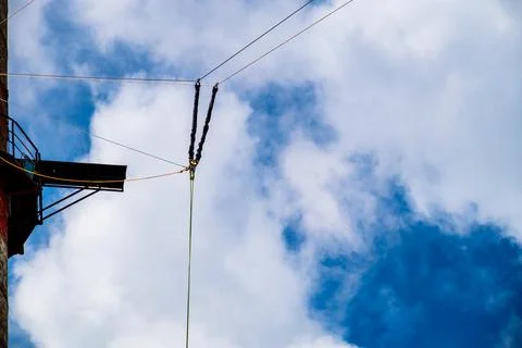 Against the background of a blue sky with clouds hangs a mount for rope jumpi Stock Photos