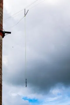 Against the background of a blue sky with clouds hangs a mount for rope jumpi Stock Photos