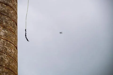 Against the background of a blue sky with clouds hangs a mount for rope jumpi Stock Photos