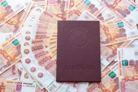Against the background of five-thousandth bills is a red diploma with honors Stock Photos