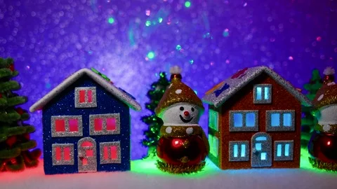 Against a background with multi-colored lighting, houses and snowmen Stock Footage 312327327