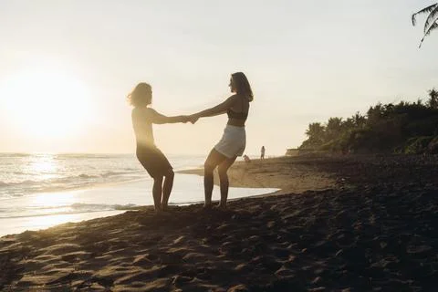 Against the background of the ocean on the shore in the rays of the sunset, a Stock Photos