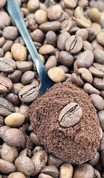 Against the background of roasted aromatic coffee beans lies a metal spoon Stock-Fotos