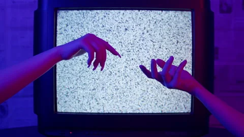Against the background of the TV, women's hands are stretched out Stock Footage 221623218