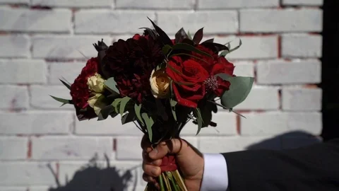 Against the background of a white brick wall appears a man's hand  Stock Footage 103395342