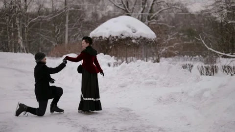 Against the background of a winter landscape, a man on skates bows to a woman in 動画素材 297601633