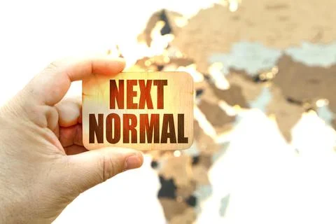Against the background of the world map, a man holds a sign with the inscript Stock Photos