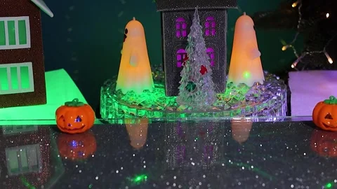 Against of a grey rotating house a pumpkin jumps between glowing pumpkins 스톡 동영상 346601646