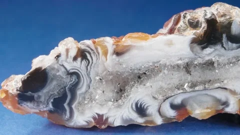The agate close-up on a blue background. A slice of mineral. Macro video of Vidéo 141215302