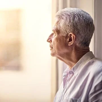 Age is a prison from which we cannot escape. a senior man looking thoughtful. Stock Photos
