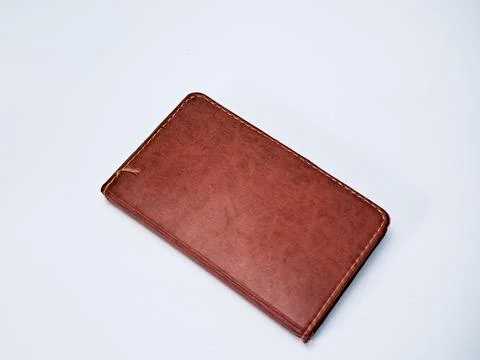 An aged and rustic brown leather notebook rests on a clean white background.. Stockfoto's