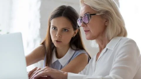 Aged apprentice young mentor working together seated at workplace desk 스톡 사진