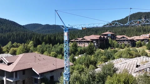 Aged blue tower crane standing over an abandoned socialist era construction site 動画素材 342727175