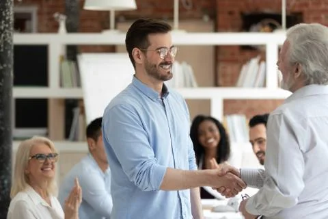 Aged boss welcoming new employee with handshake symbol of respect Stock Photos