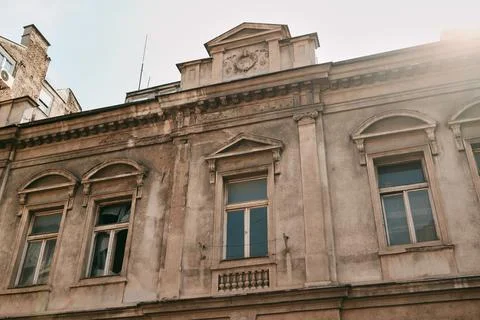 Aged building facade with worn textures and vintage architectural elements in Stock Photos