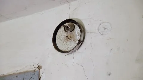 Aged ceiling with cobwebs, cracks and a metal light fixture attached. Video stock 294048270