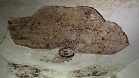 Aged ceiling with visible cracks and a metal light fixture attached. Video stock 294048182