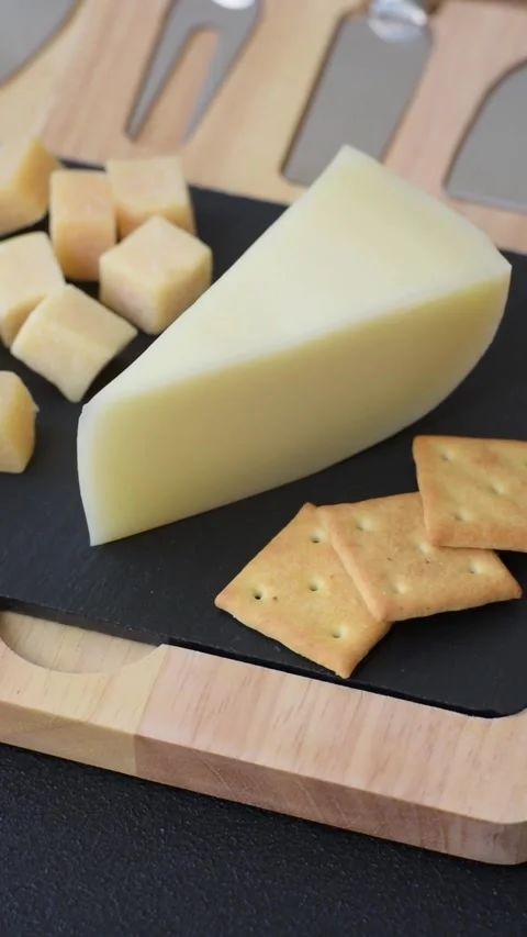 Aged cheese in a triangular block with jam, figs, and nuts. Aged cheese Stock Footage 336245024