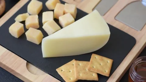 Aged cheese in a triangular block with jam, figs, and nuts. Aged cheese Stock Footage 336245026
