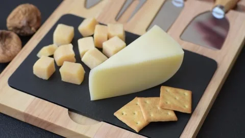 Aged cheese in a triangular block with jam, figs, and nuts. Aged cheese Stock Footage 336245028