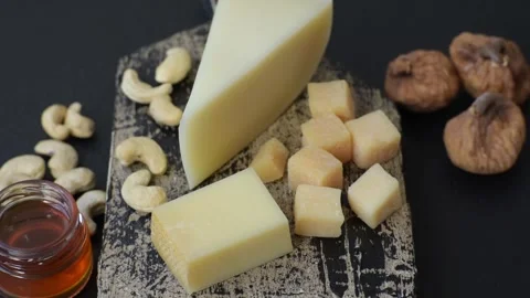 Aged cheese in a triangular block with jam, figs, and nuts. Aged cheese Stock Footage 336245030