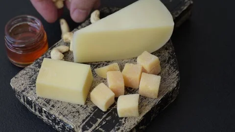 Aged cheese in a triangular block with jam, figs, and nuts. Aged cheese Stock Footage 336245031