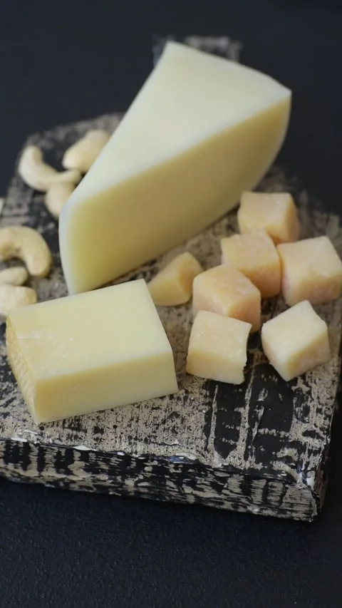Aged cheese in a triangular block with jam, figs, and nuts. Aged cheese Stock Footage 336245035
