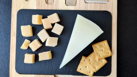 Aged cheese in a triangular block with jam, figs, and nuts. Aged cheese Stock Footage 336245068