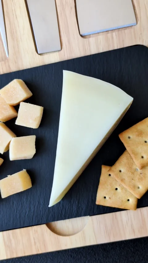 Aged cheese in a triangular block with jam, figs, and nuts. Aged cheese Stock Footage 336245083