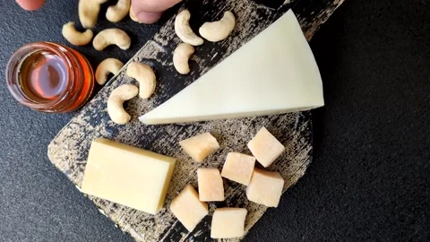 Aged cheese in a triangular block with jam, figs, and nuts. Aged cheese Stock Footage 336245093