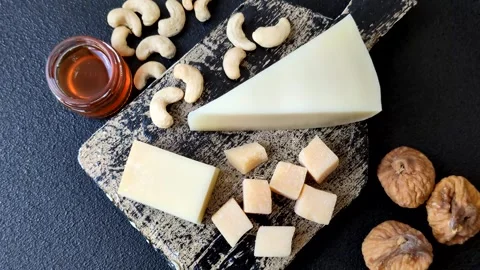 Aged cheese in a triangular block with jam, figs, and nuts. Aged cheese Stock Footage 336245102